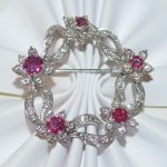 Ladies 18kt white gold ruby and diamond floral circle pin