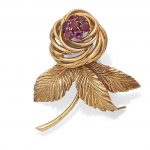 A ruby brooch, by Van Cleef & Arpels, circa 1945 The flower with realistically modelled leaves issuing an openwork flower head with circular-cut ruby