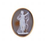 A cameo brooch. The oval agate panel depicting a female with a bow
